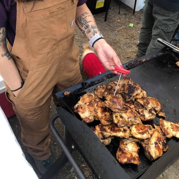 Camper checking chicken internal temp